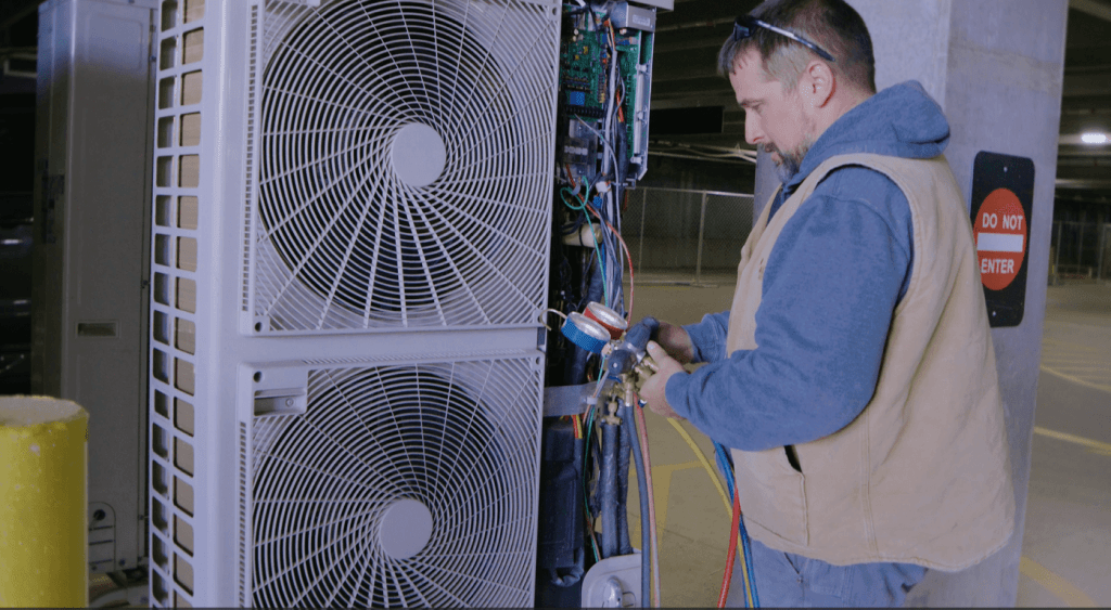 Climate Systems employee performing HVAC repairs